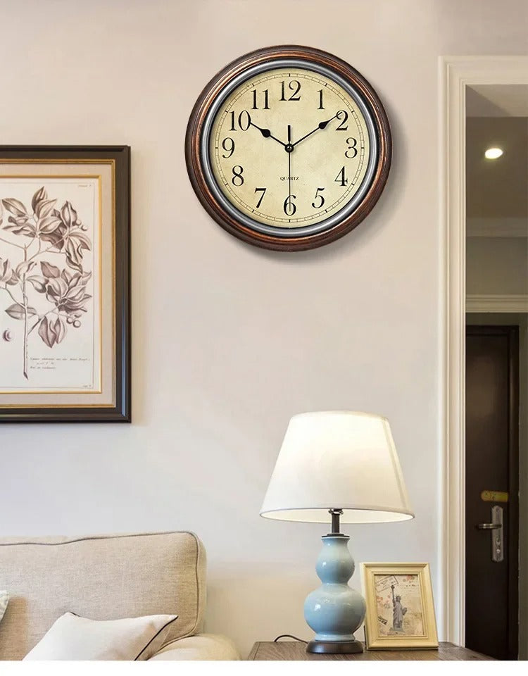 "Classic wall clock with Roman numerals on a round face, elegant design for home decor, blends with varied interiors."