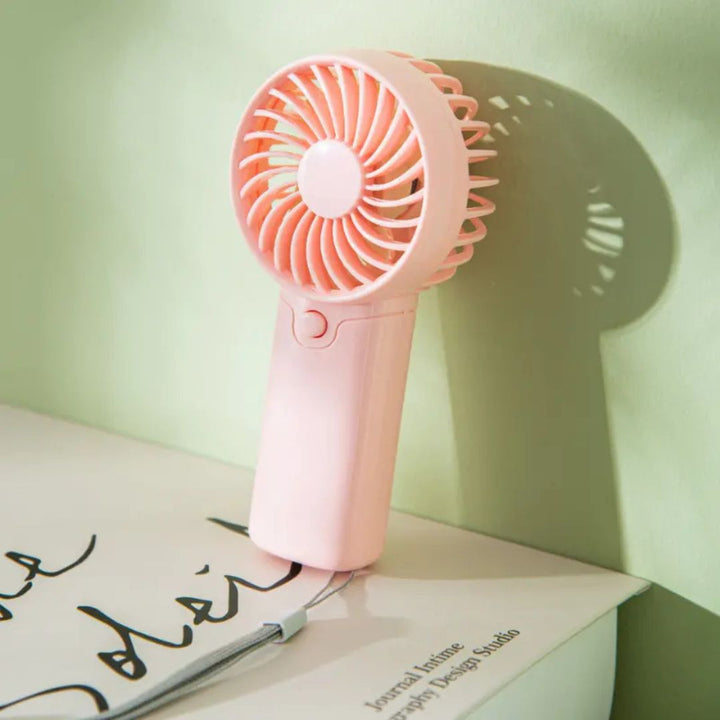 "Compact portable mini fan, sleek design in white, pocket-sized cooler for travel or office, beauty wellbeing essential."