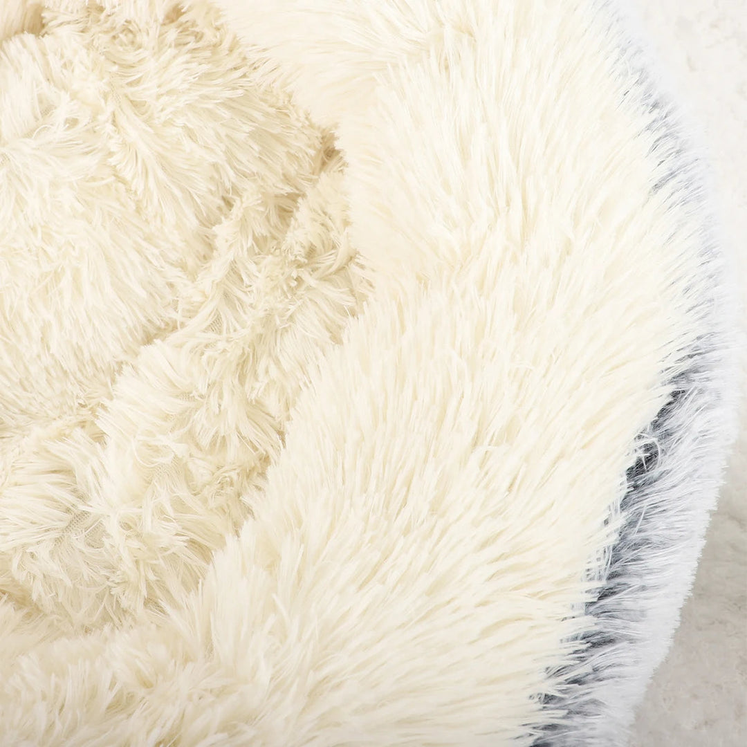 "Cozy plush donut dog bed with deep sides, faux fur, circular shape for comfort and anxiety relief in various sizes."