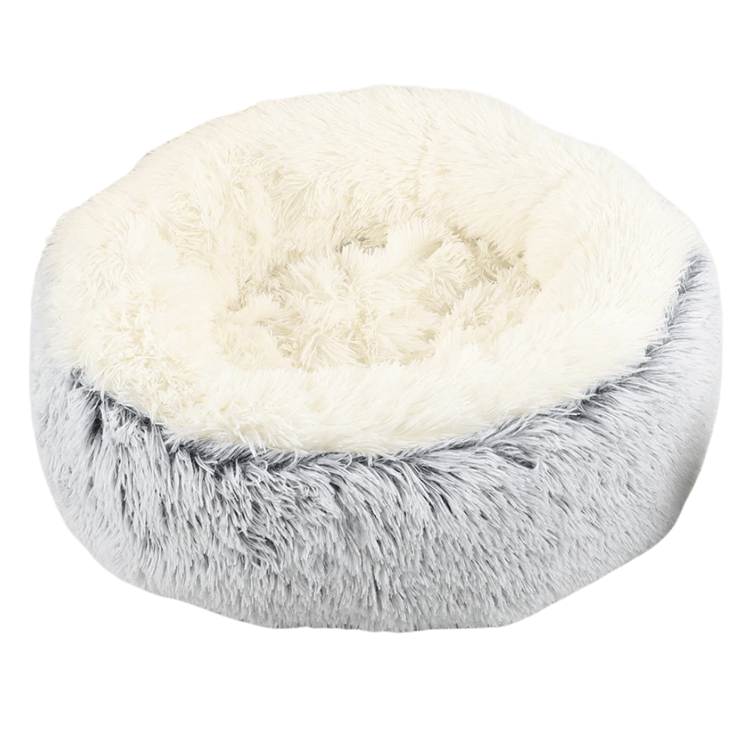 "Cozy plush donut dog bed with deep sides, faux fur, circular shape for comfort and anxiety relief in various sizes."