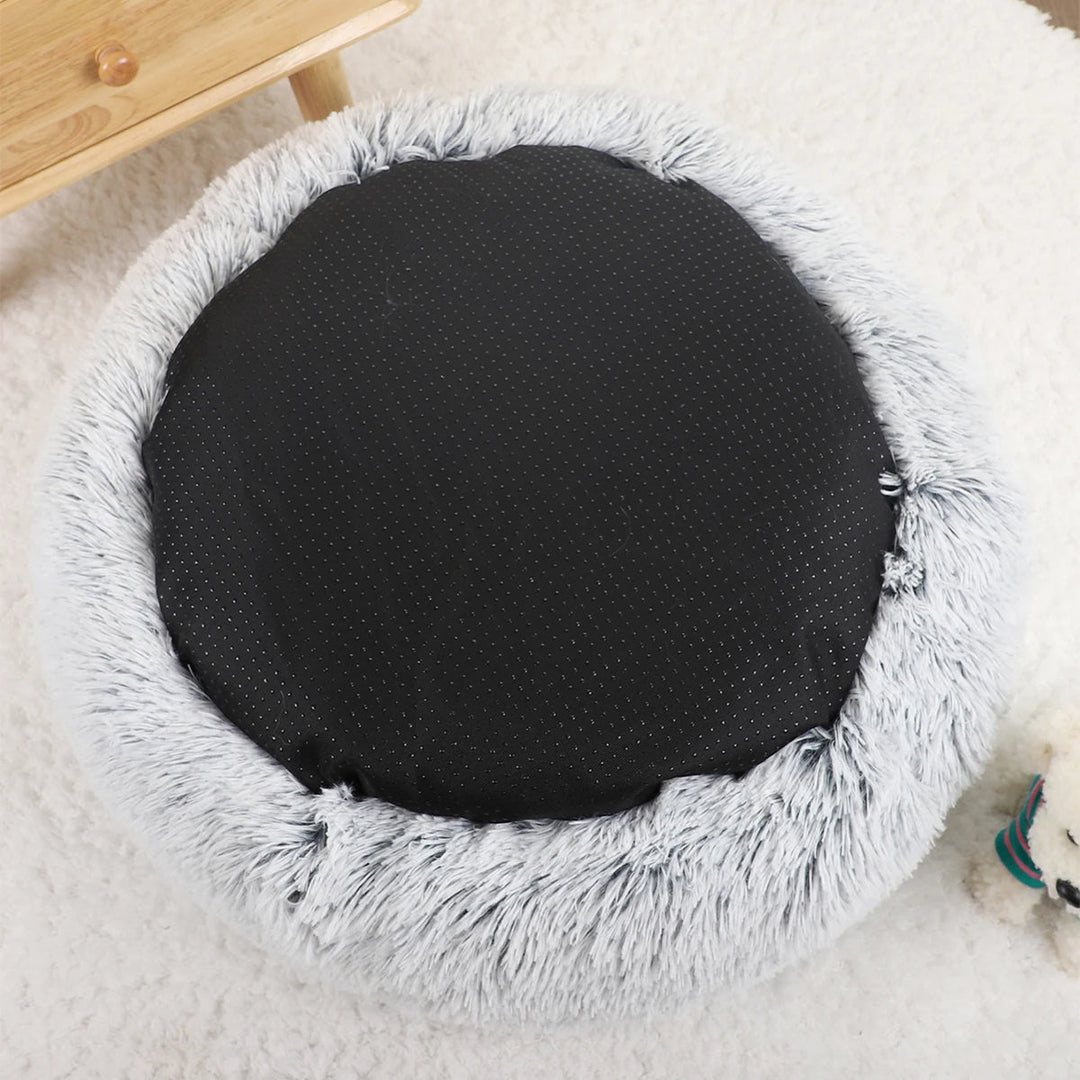 "Cozy plush donut dog bed with deep sides, faux fur, circular shape for comfort and anxiety relief in various sizes."