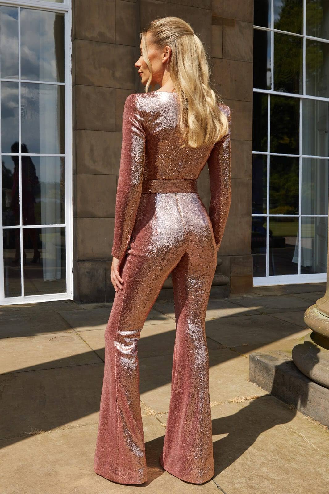 Dazzling women's long sleeve sequin jumpsuit with flared legs, perfect for evening events and dramatic style.