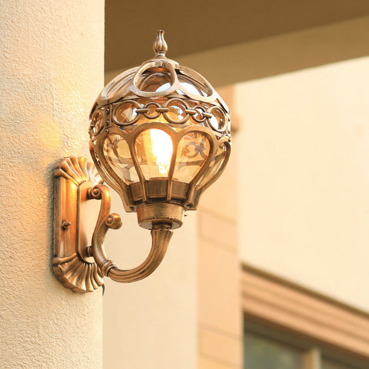 "Elegant bronze/black outdoor wall light with matte finish, transparent globe shade, perfect for garden or porch lighting."