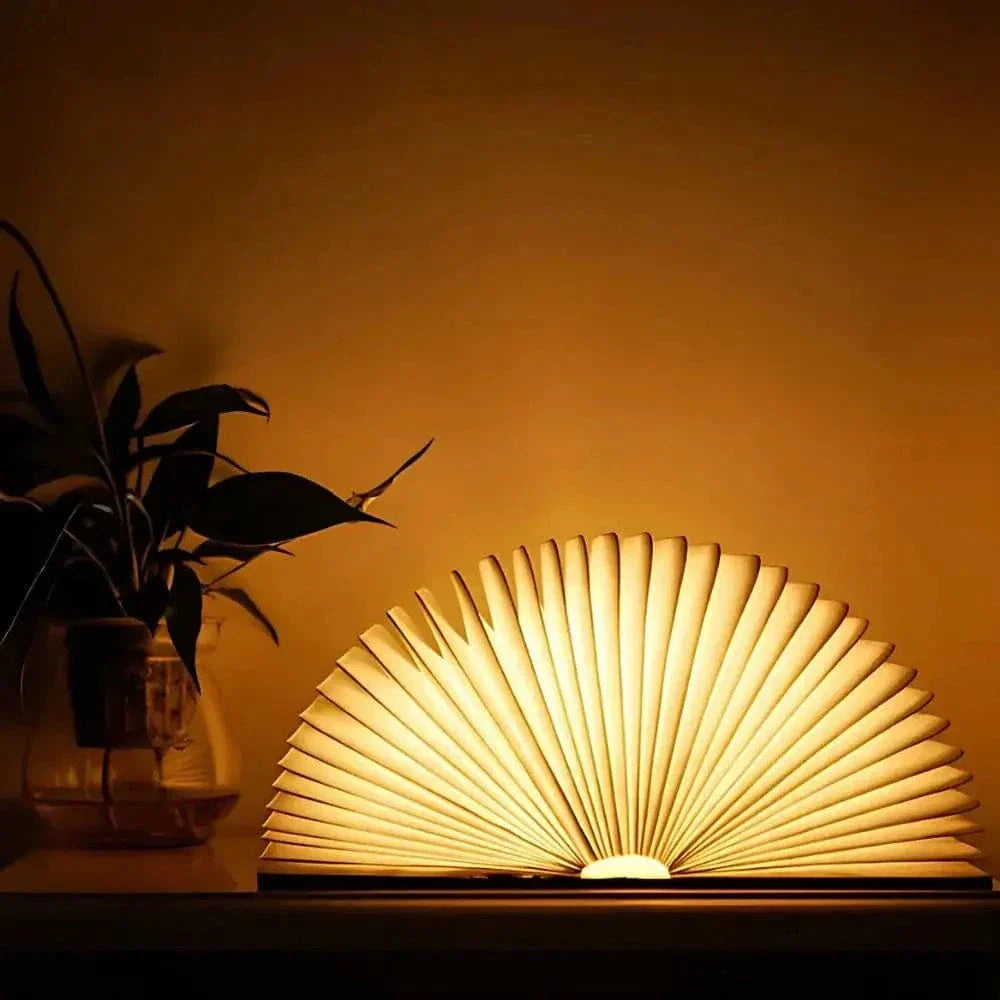 "Elegant foldable LED book lamp, warm white light, 360-degree design, portable for home or travel, wood and paper material."