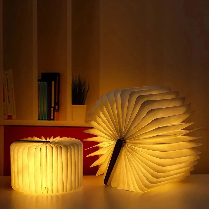 "Elegant foldable LED book lamp, warm white light, 360-degree design, portable for home or travel, wood and paper material."