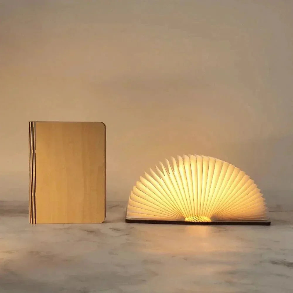 "Elegant foldable LED book lamp, warm white light, 360-degree design, portable for home or travel, wood and paper material."