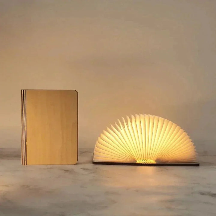 "Elegant foldable LED book lamp, warm white light, 360-degree design, portable for home or travel, wood and paper material."