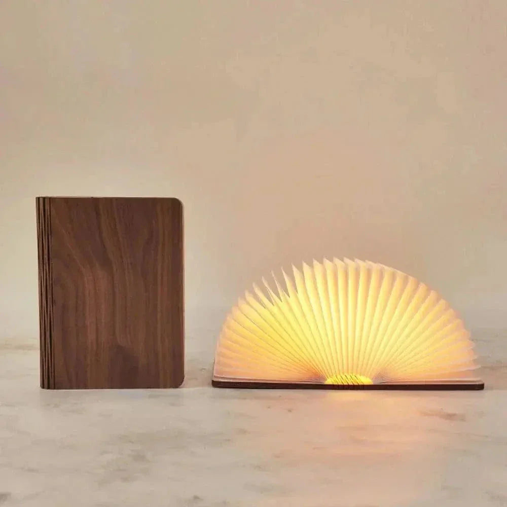"Elegant foldable LED book lamp, warm white light, 360-degree design, portable for home or travel, wood and paper material."
