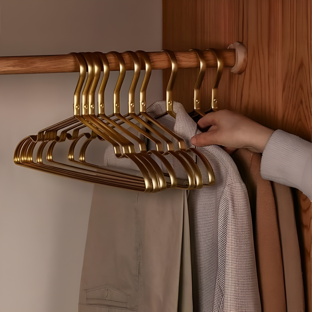 "Elegant gold and silver anti-slip clothes hangers with velvet finish, slim design, and 360° chrome swivel hook in closet."