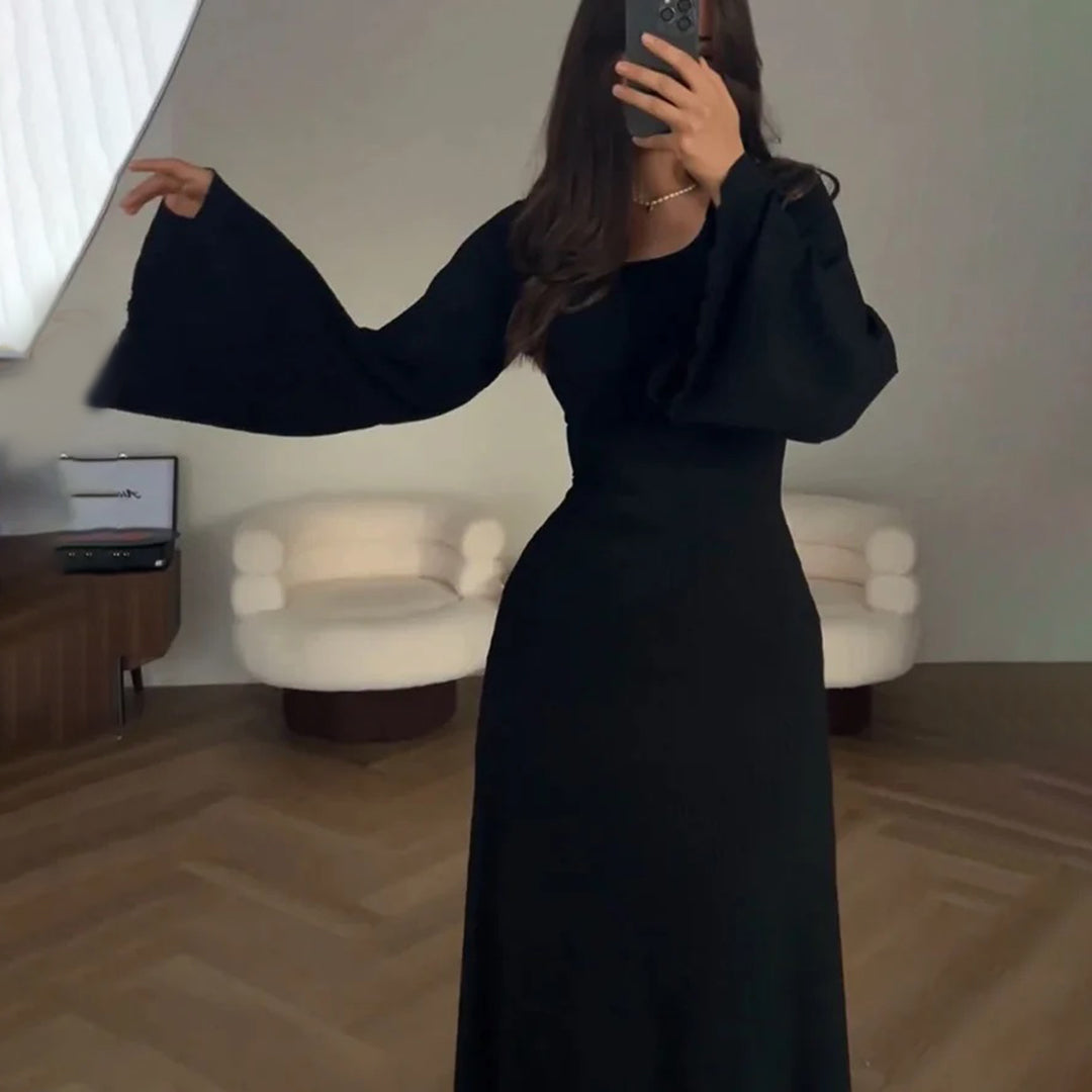 Elegant knit maxi dress with long sleeves in solid brown, featuring a round neckline and wide sleeves for a chic look.