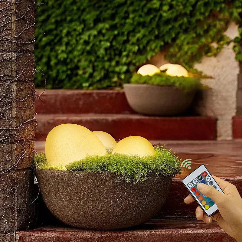 Elegant LED garden light with cobblestone design, glowing in multiple colors, ideal for illuminating outdoor spaces like gard