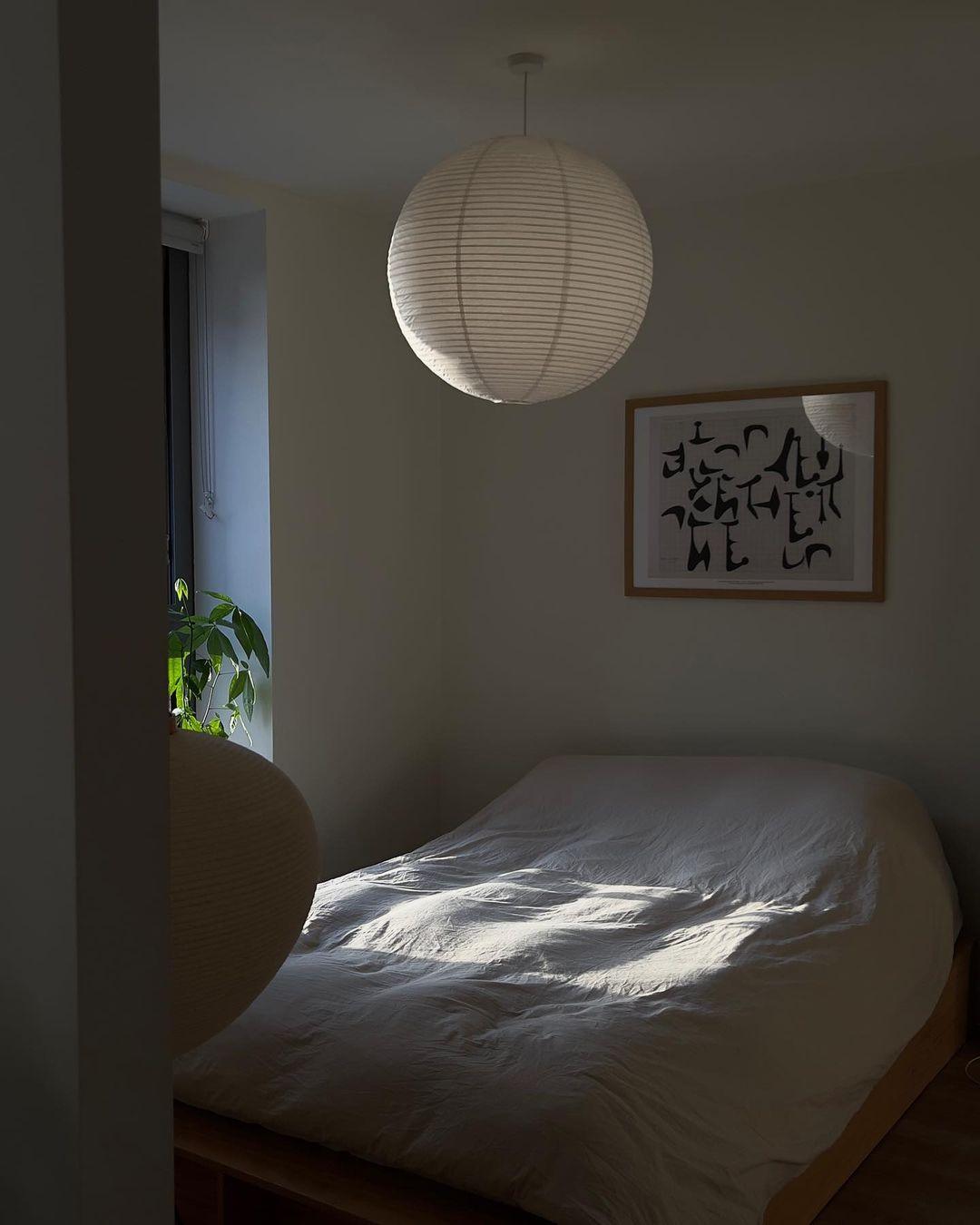 "Elegant modern Japanese paper lantern pendant light with a warm glow, blending contemporary and mid-century design."