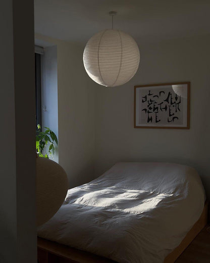 "Elegant modern Japanese paper lantern pendant light with a warm glow, blending contemporary and mid-century design."