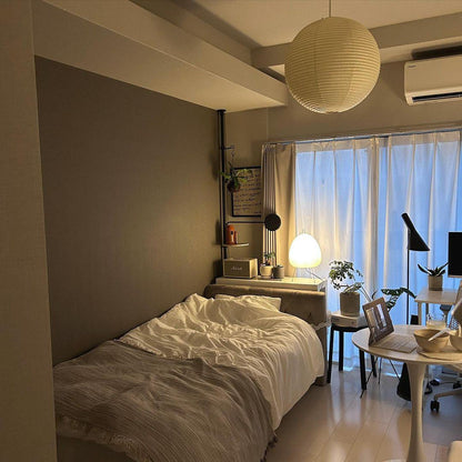 "Elegant modern Japanese paper lantern pendant light with a warm glow, blending contemporary and mid-century design."