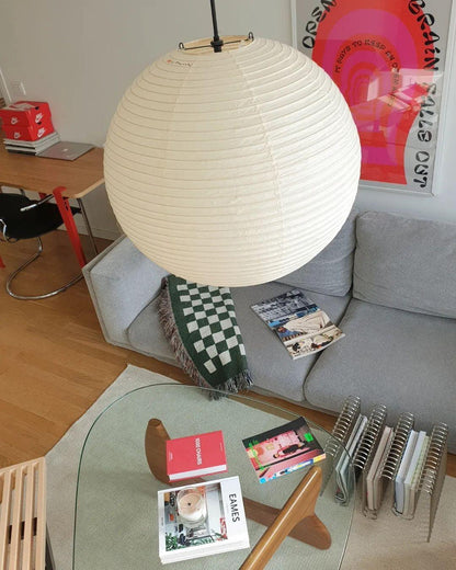 "Elegant modern Japanese paper lantern pendant light with a warm glow, blending contemporary and mid-century design."