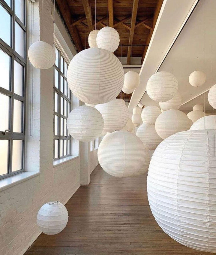 "Elegant modern Japanese paper lantern pendant light with a warm glow, blending contemporary and mid-century design."