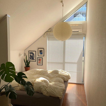 "Elegant modern Japanese paper lantern pendant light with a warm glow, blending contemporary and mid-century design."