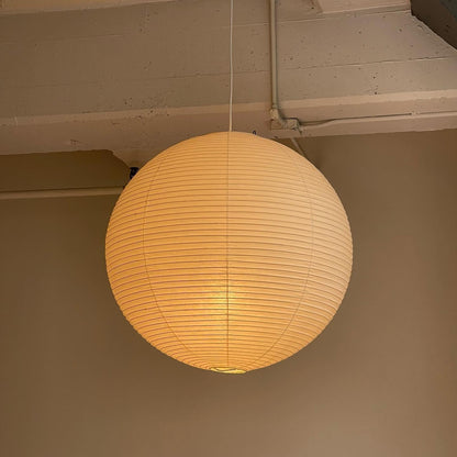 "Elegant modern Japanese paper lantern pendant light with a warm glow, blending contemporary and mid-century design."