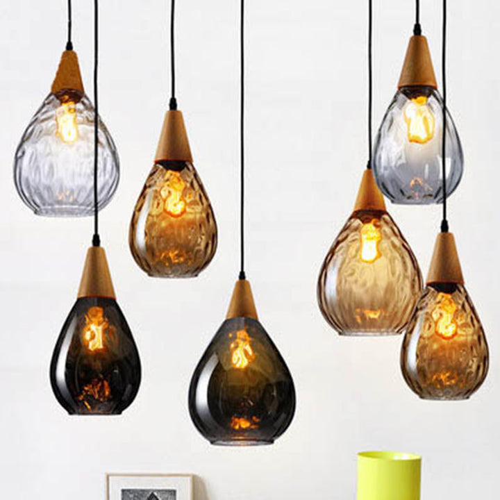 "Elegant teardrop glass pendant light with wood accents, available in clear, golden, smoky gray, perfect for any home decor."