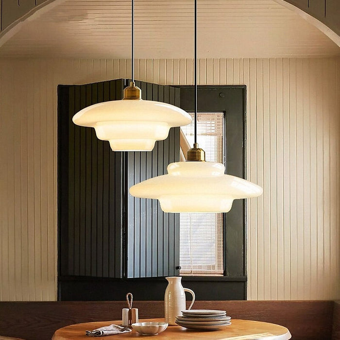 Elegant white glass pendant light with brass fixture, mid-century design, perfect for modern or classic interiors, adds luxur