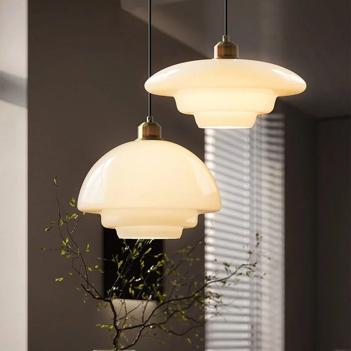 Elegant white glass pendant light with brass fixture, mid-century design, perfect for modern or classic interiors, adds luxur