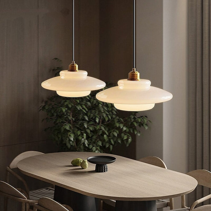 Elegant white glass pendant light with brass fixture, mid-century design, perfect for modern or classic interiors, adds luxur