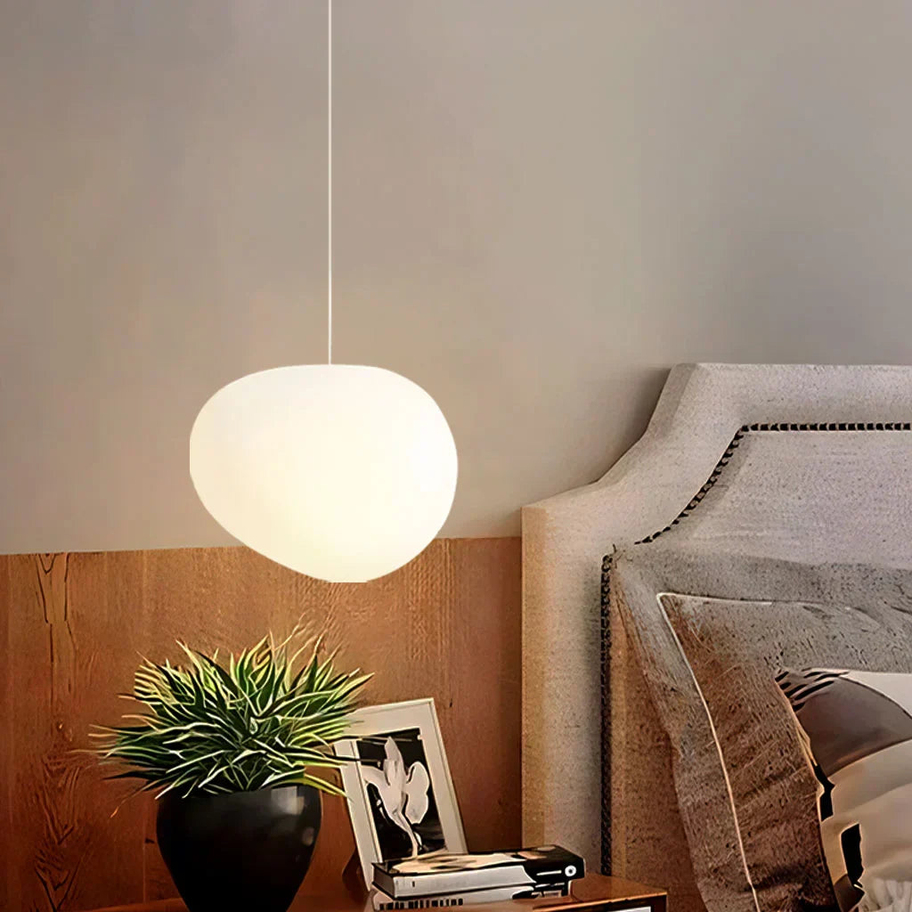 Elegant white pebble pendant light; minimal design, frosted glass, metal accents, soft glow for modern interiors.