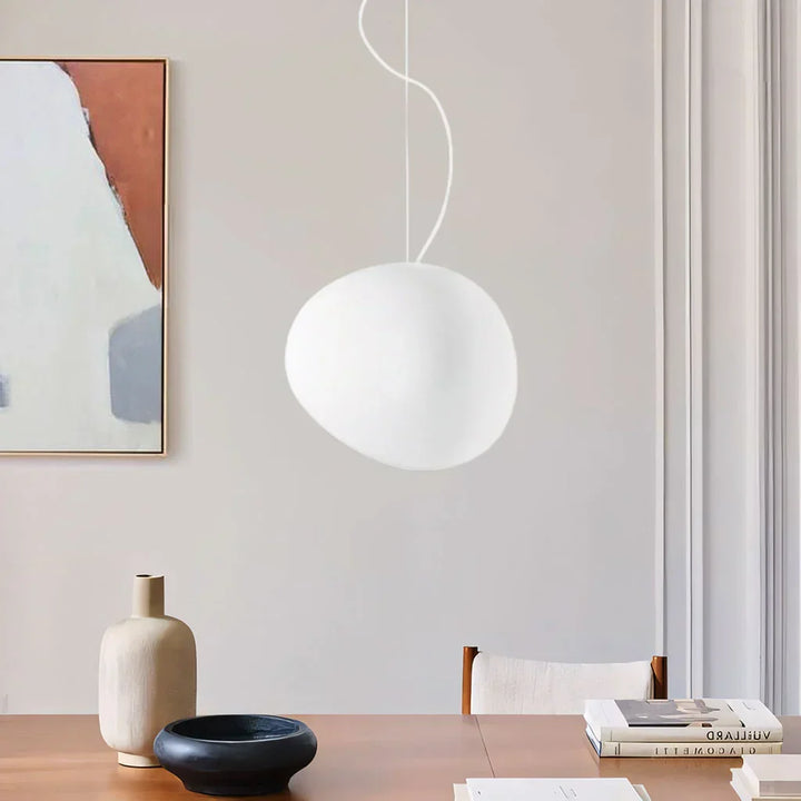 Elegant white pebble pendant light; minimal design, frosted glass, metal accents, soft glow for modern interiors.