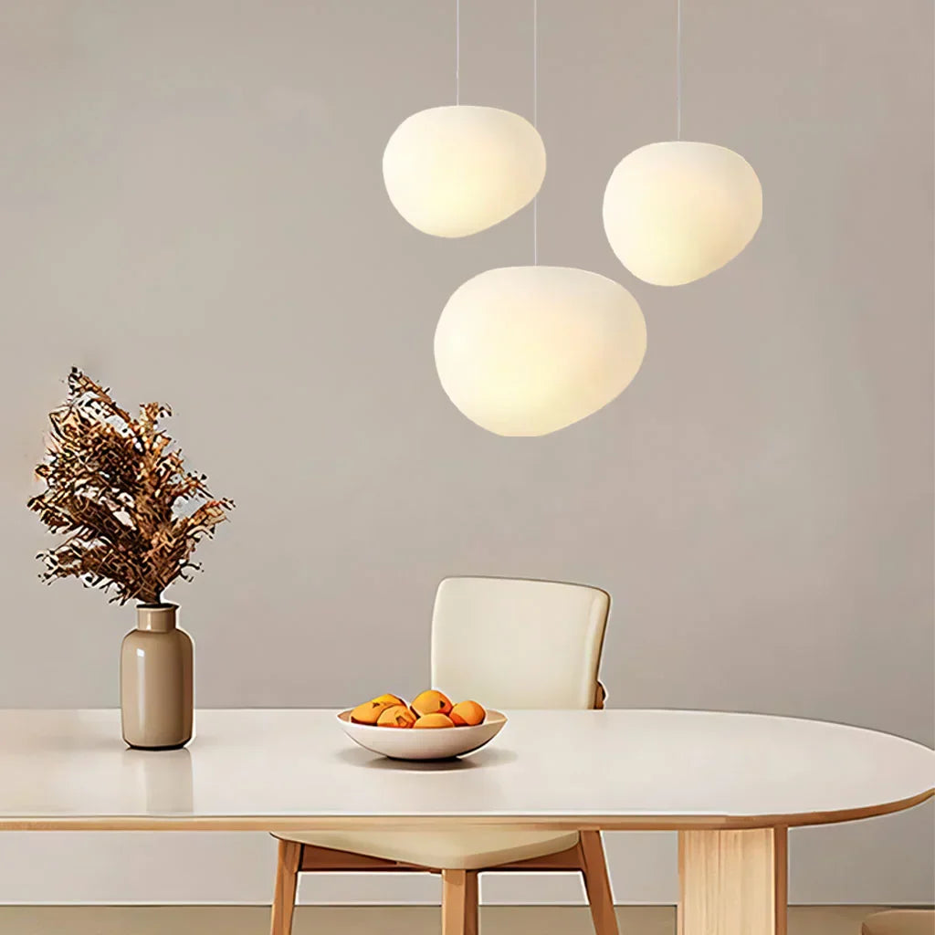 Elegant white pebble pendant light; minimal design, frosted glass, metal accents, soft glow for modern interiors.