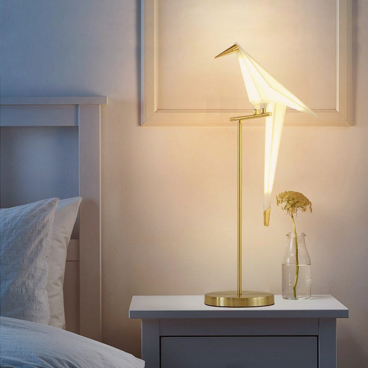 "Elegant wireless origami bird lamp with magnetic attachment emitting warm light; enhances home decor with artistic design."