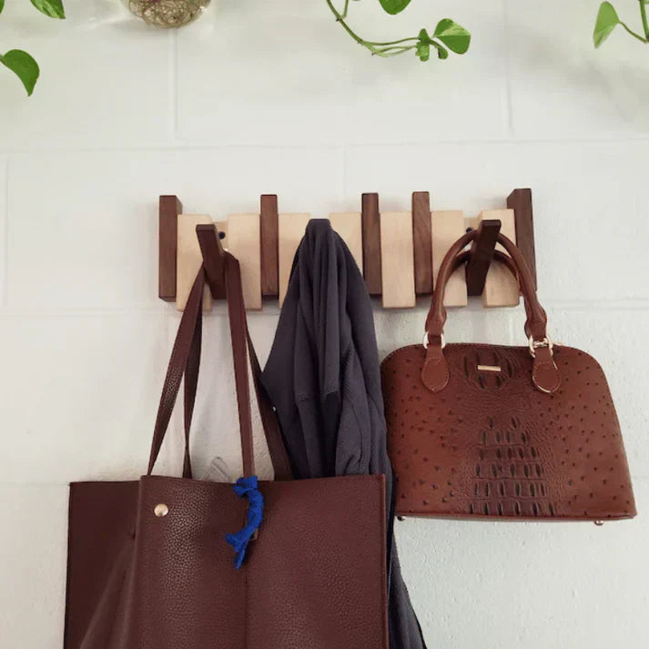 "Elegant wooden coat rack with piano key design, featuring multiple hooks for organizing coats and accessories."