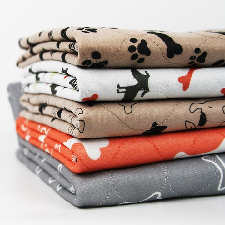 "Gray waterproof dog pee pad, washable and reusable, with bone and paw print. Available in multiple sizes for pet use."