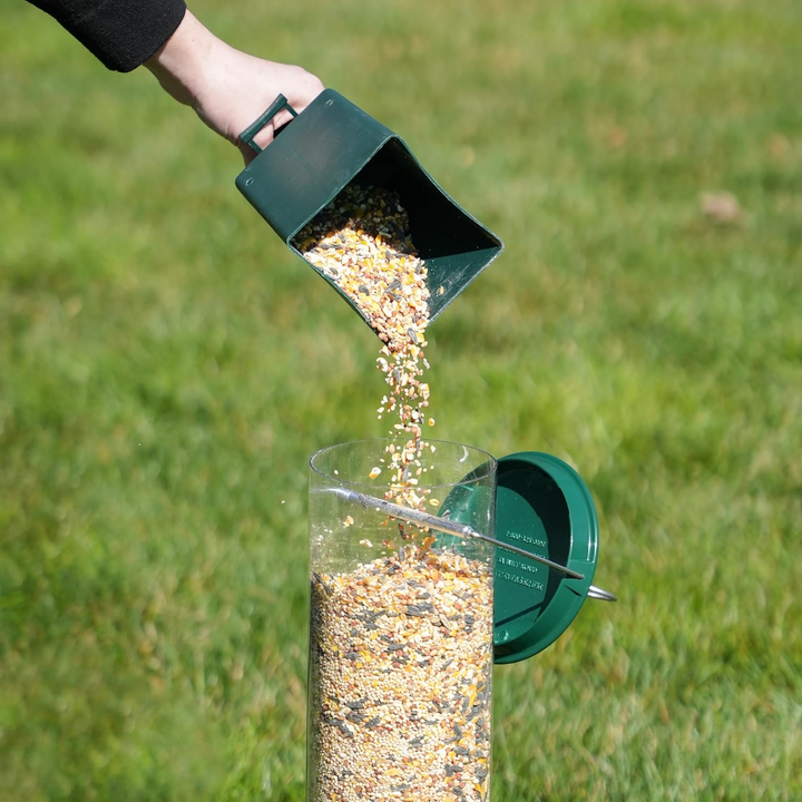 "Heavy-duty squirrel-proof bird feeder with metal weather-resistant design and rotating perch in garden setting."