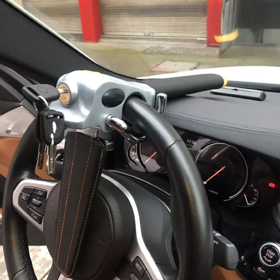 "High-visibility silver-black steering wheel lock with universal fit, durable steel-aluminum build, protects from theft."