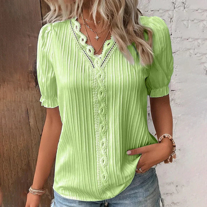 Lace V-neck blouse with short puffed sleeves, pleated fabric, women's elegant clothing, front view.
