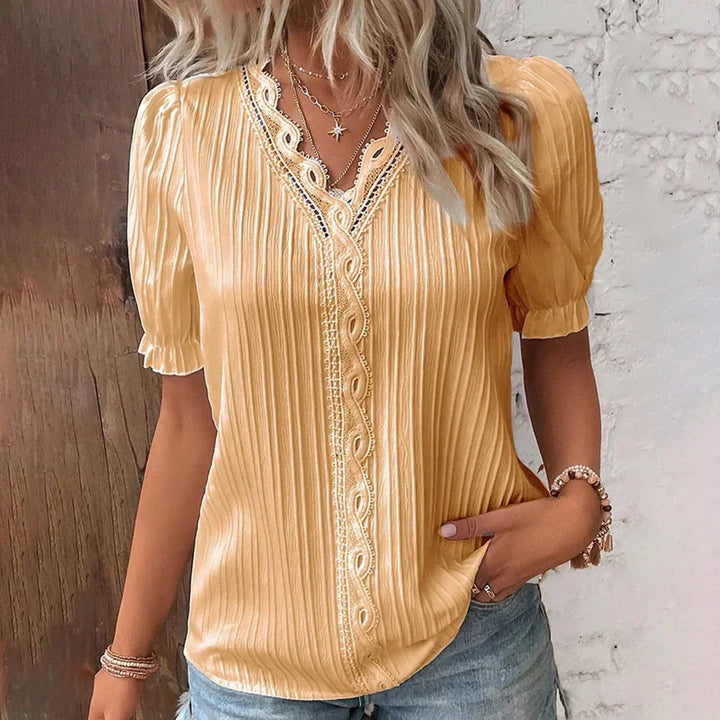 Lace V-neck blouse with short puffed sleeves, pleated fabric, women's elegant clothing, front view.