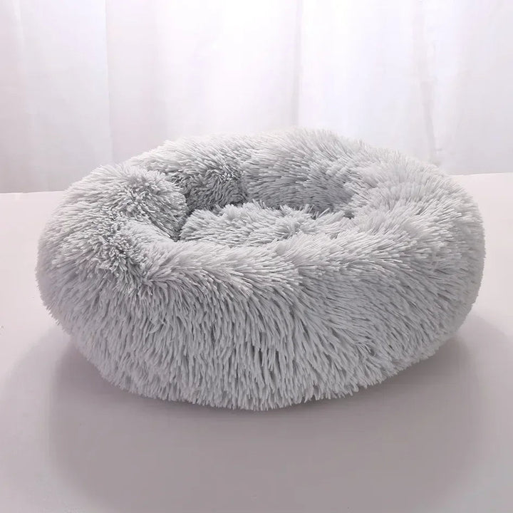 "Light grey premium dog bed offering comfort for pets, featuring plush design and elevated edges for head and neck support."