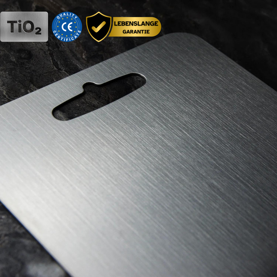 Medical grade titanium cutting board with non-porous silver surface, rounded edges, and ergonomic design for ultimate hygiene