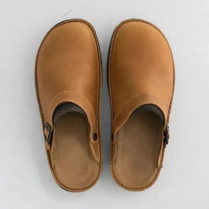 "Men's brown leather slippers, sleek design, breathable, ideal for indoor and outdoor wear, provide comfort and support."