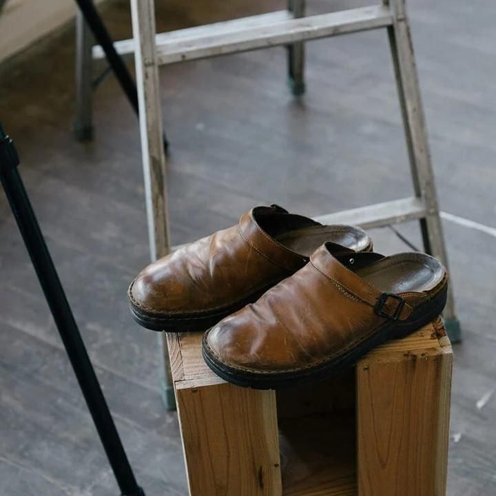 "Men's brown leather slippers, sleek design, breathable, ideal for indoor and outdoor wear, provide comfort and support."