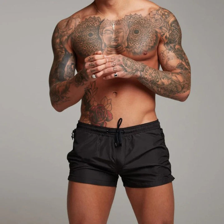 "Men's quick-dry, stretchy swim shorts with pockets in vibrant colors, featuring an elastic waistband and sleek design."