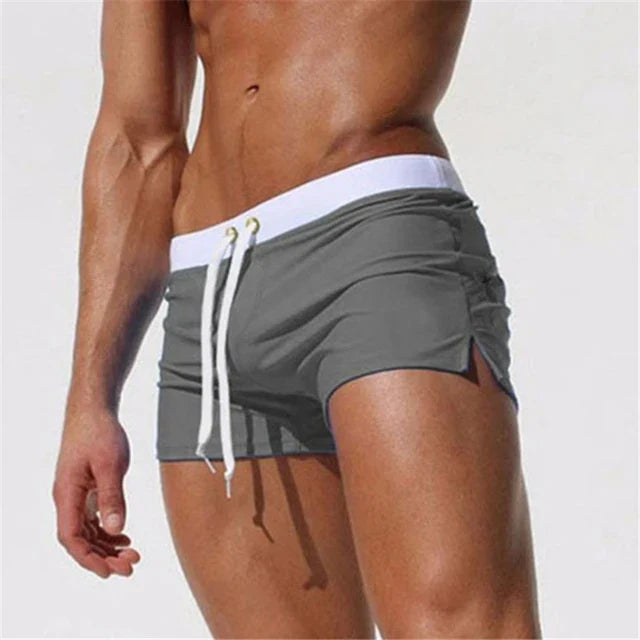 "Men's quick-dry swim shorts with adjustable waistband, sleek design, side slits, and drawstring closure for swim comfort."