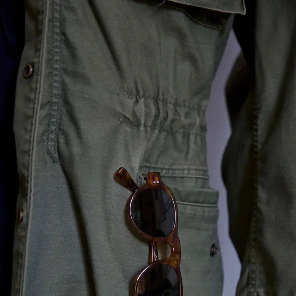 Men's vintage cotton field jacket with adjustable waist, rugged design, breathable fabric, suitable for layering.