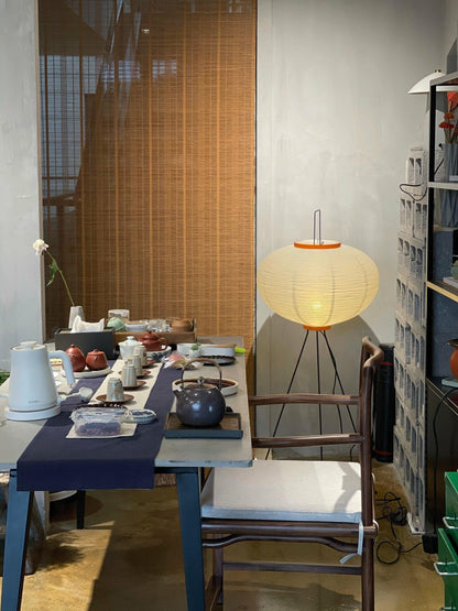 "Minimalist rice paper floor lamp with sleek metal frame and soft diffused light, perfect for creating a warm ambiance."