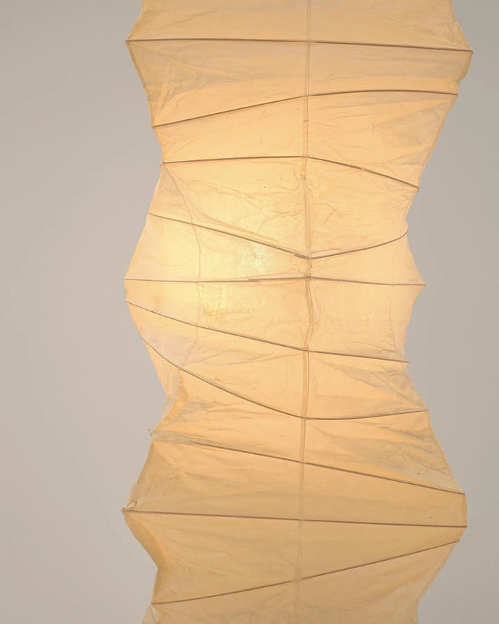 "Minimalist rice paper floor lamp with sleek metal frame and soft diffused light, perfect for creating a warm ambiance."