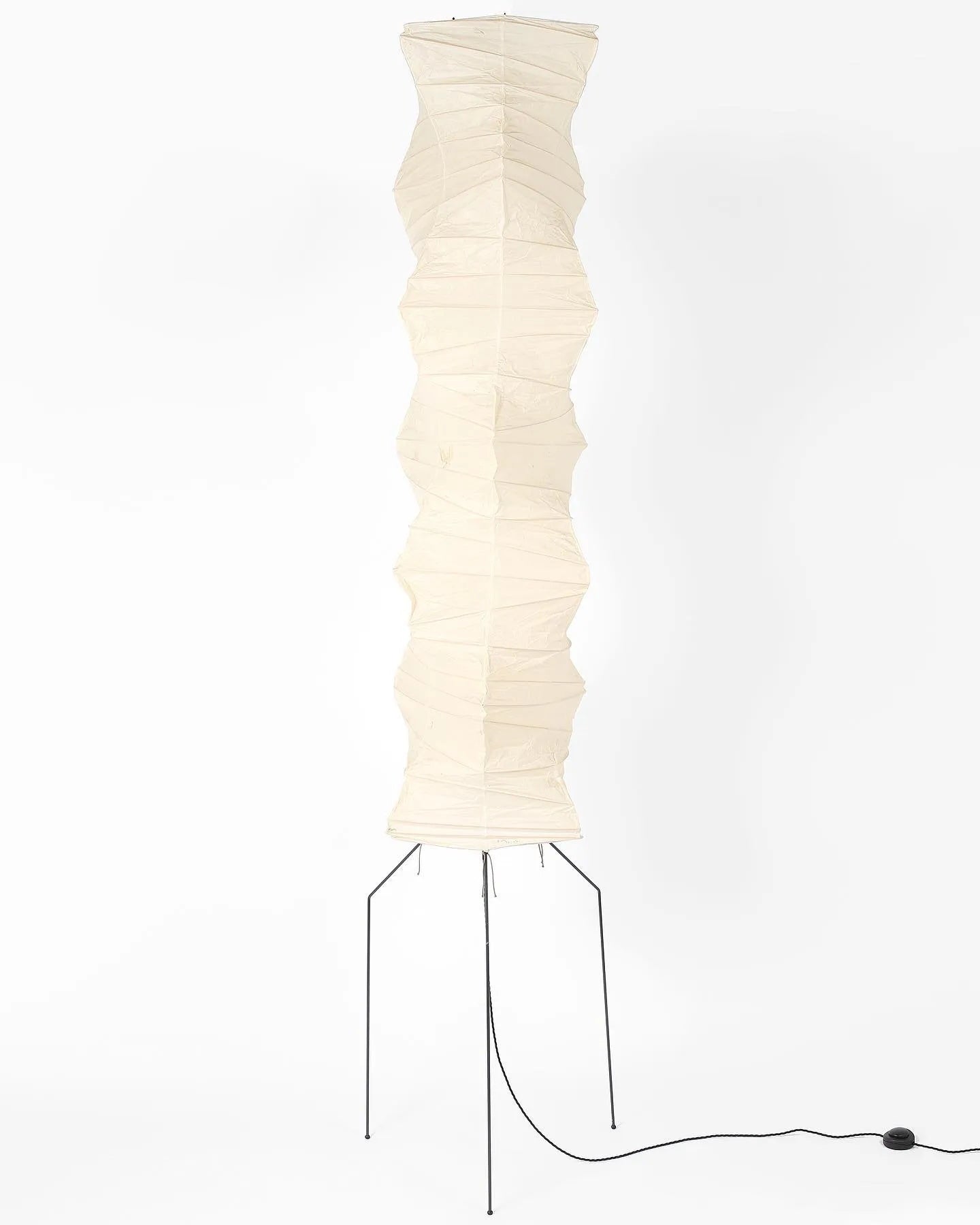 "Minimalist rice paper floor lamp with sleek metal frame and soft diffused light, perfect for creating a warm ambiance."