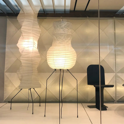 "Minimalist rice paper floor lamp with sleek metal frame and soft diffused light, perfect for creating a warm ambiance."