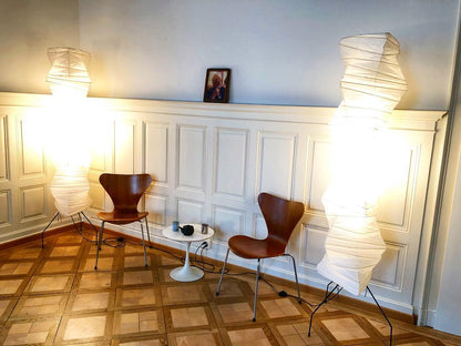 "Minimalist rice paper floor lamp with sleek metal frame and soft diffused light, perfect for creating a warm ambiance."