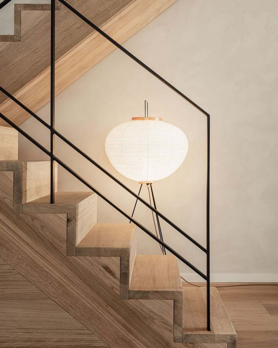 "Minimalist rice paper floor lamp with sleek metal frame and soft diffused light, perfect for creating a warm ambiance."