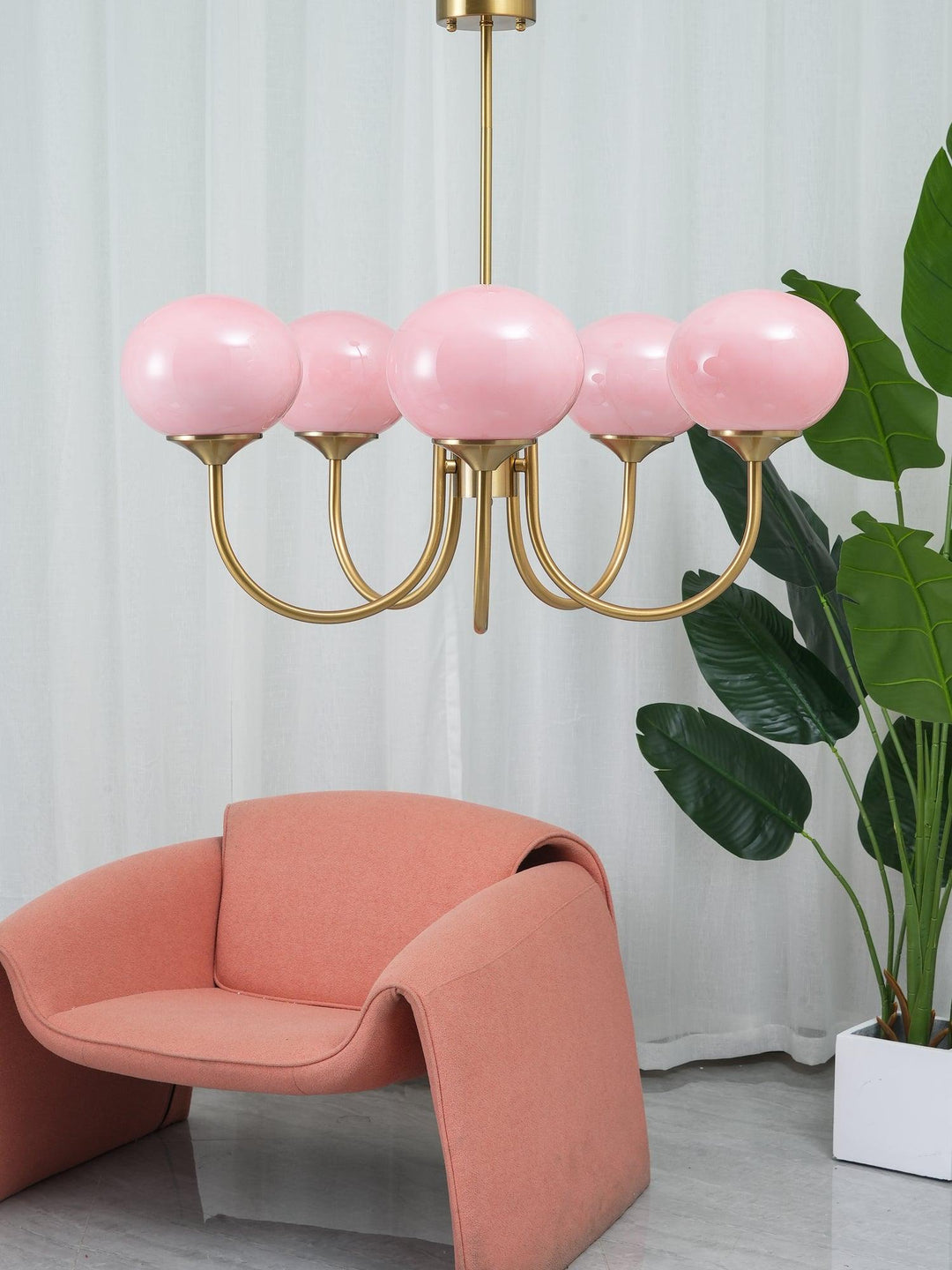 Modern pink and gold chandelier with elegant glass shades, ideal ceiling light fixture for chic home decor and illumination.